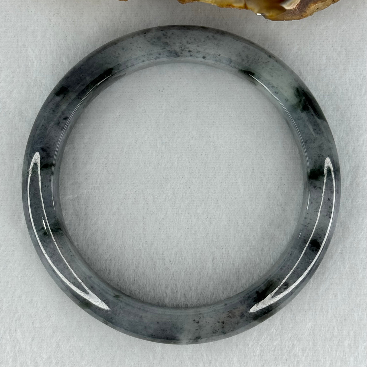 Type A Translucent Faint Grey with Greyish Black Patches Jadeite Bangle Internal Diameter 58.55mm 289.81cts 58.40g 11.8 by 8.6mm With NGI Cert 32885981 (Very Slight Internal Lines)